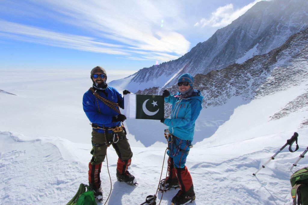 two climbers waving pakistani flag